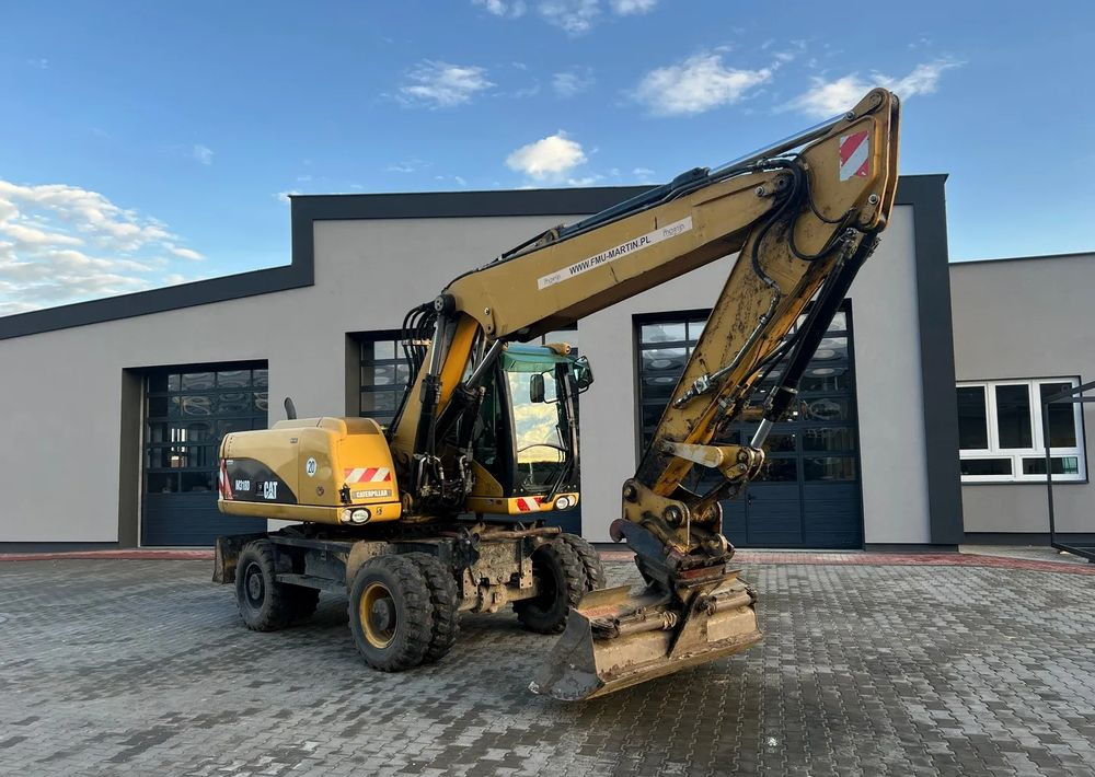 CAT Caterpillar M318D - Ratinis ekskavatorius: foto 1 CAT Caterpillar M318D - Ratinis ekskavatorius: foto 1
